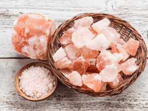 Is it safe to put pink Himalayan salt in your water? This is a photo of a whole pink Himalayan rock, broken up chunks of pink Himalayan rock, and coarsely ground pink Himalayan rock which is used for salting food. In this article we discuss the potential benefits and downfalls of using pink Himalayan salt.